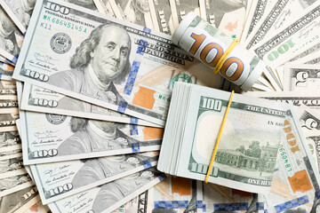 Fototapeta premium Close up of 100 dollar bills pile on background made with different dollar banknotes. Top view of financial concept