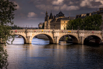 Fototapeta na wymiar Paris, France - June 9, 2020: Nice view of Pont Neuf bridge and Conciergerie in background on a stormy end of the day in Paris