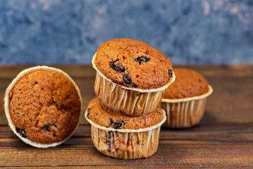 Several fragrant muffins with blueberries are on the table, next to blueberries and mint.