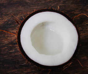 
sliced ​​coconut on a wooden plate with with fresh mint leaves.