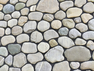 Light gray stones on black background. Wall texture