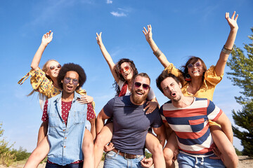 Obraz premium Young men giving his girlfriends a piggyback ride