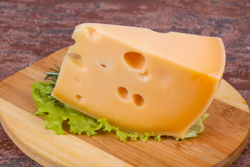 Maasdam cheese  in the board served salad leaves