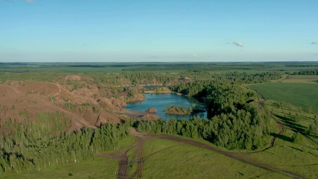 Romantsevo hills and lakes in Tula oblast pan drone aerial shot. High quality 4k footage fly over pan shot left to right of tulskaya oblast romantsevskie hills, konduki shot under cloudy blue sky