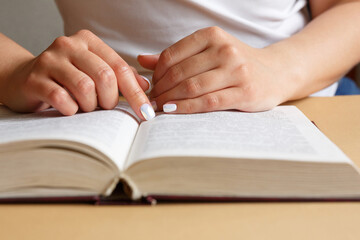 A woman is reading a book. Hands are holding a book. Beautiful manicure. A student is studying a...
