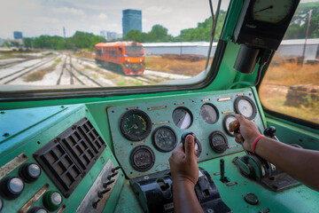 Hand of driver is managing locomotive of train on the railway.