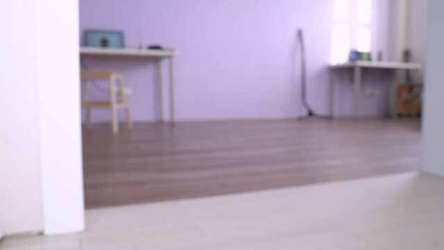 Cute little dachshund wearing blue shirt stands looking into opened fridge, barks, closes the door and runs away. Concept of dieting, healthy food, feeding pets. Indoors, apartment background.