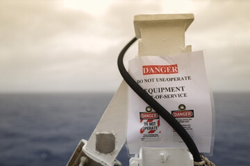 Danger out of services sign placing on black cable 