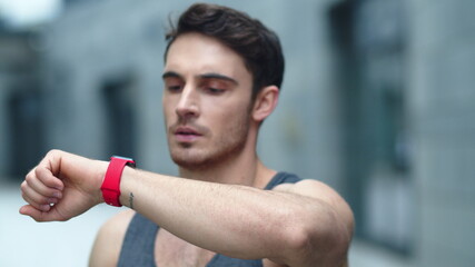 Fototapeta na wymiar Closeup male athlete using smart clock outside. Fit man setting smart watch