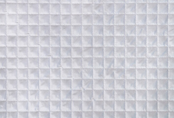 White fabric texture with checkered mesh embossing. Abstract material pattern, background or texture. Empty blank or template.