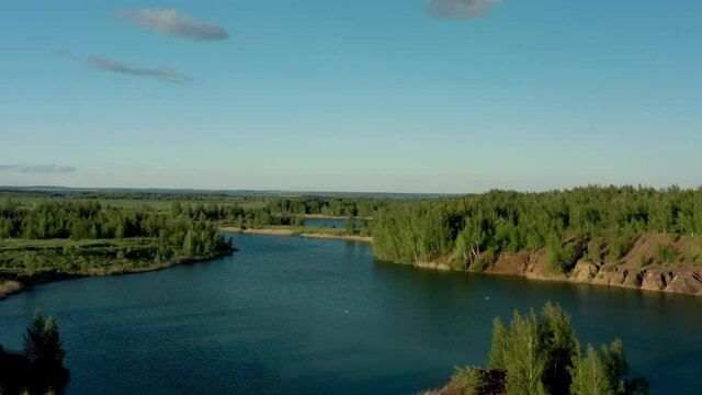 Romantsevo hills and lakes in Tula oblast drone aerial shot drone aerial pan shot left to right. Fly over tulskaya oblast romantsevskie hills, konduki shot under cloudy blue sky