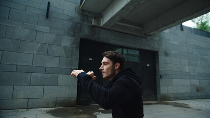 Man boxer training punch on workout outdoor. Sportsman practicing boxing beats