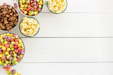 Fototapeta na wymiar Colorful popcorn in bowl on white desk top-view copy space