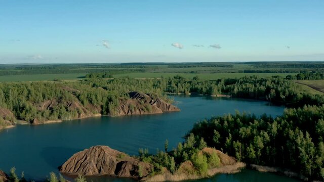 Romantsevo hills and lakes in Tula oblast drone aerial shot drone aerial zoom out. Fly over tulskaya oblast romantsevskie hills, konduki shot under cloudy blue sky