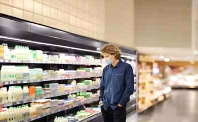 Supermarket shopping, face mask and gloves,Young man shopping in supermarket, reading product information