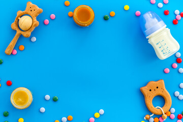 Baby accessories and toys on blue table top-down copy space