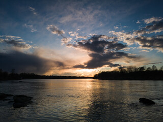 Fototapeta premium Beautiful sunset landscape by the river with a rocky shore.