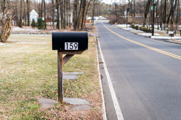 Black metal mailbox number 159 before Glenside Ave in Scotch Plains, New Jersey. Empty street. Cold winter. No traffic, no cars.