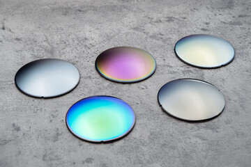 Close up of optical lenses for sunglasses with different color. Production and adjust of new eyeglasses lens in optics. Eyesight concept
