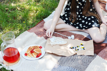 Little girl creates a ceramic mosaic on a plaid in the garden.