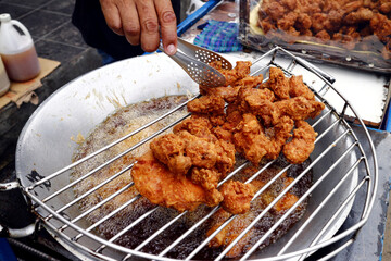 Deep fried chicken sold at a food cart along a sidewalk