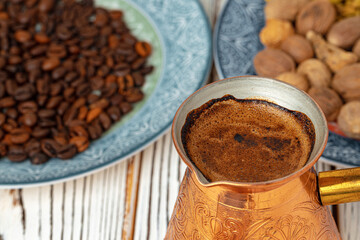 Coffee in metal turk with spices in a plate
