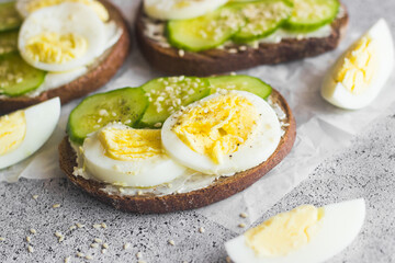Sandwiches with egg, cucumber, sesame seeds and spices. Tasty breakfast. Sandwiches on the table