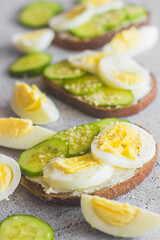 Sandwiches with egg, cucumber, sesame seeds and spices. Tasty breakfast. Sandwiches on the table