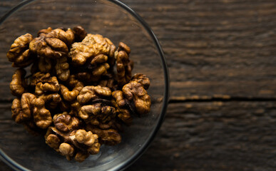 Walnut in a small plate on a vintage wooden table. Walnuts is a healthy vegetarian protein nutritious food. Natural nuts snacks.
