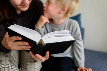 Fototapeta premium Mother and child reading book and smiling