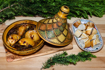 Moroccan mutton meat tagine dish with apple-quinces on top in open traditional tagine pot. Tajine...