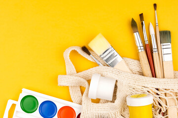 Top view of paint and brush for drawing in eco bag. Copy space flatlay.
