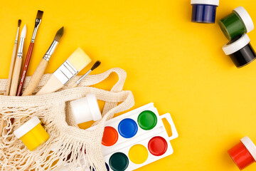 Top view of paint and brush for drawing in eco bag. Copy space flatlay.