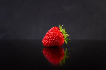 Sweet fresh ripe strawberry isolated on dark background.