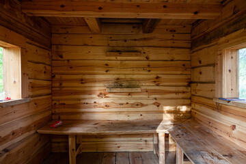 Interior of wooden simple tourist hut shelter. Benches next to walls. Ladder entrance upstairs. Estonia, Europe.