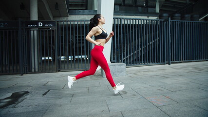 Female runner training outdoor in slow motion. Fitness woman running on street