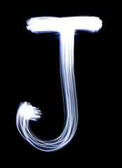 Handwrite letter J, made with light painting technic isolated on black. Light effect font of full alphabet set of upper case letters.