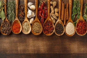 Fotobehang Vivid colorful spices in wooden spoons on wooden background © fotofabrika