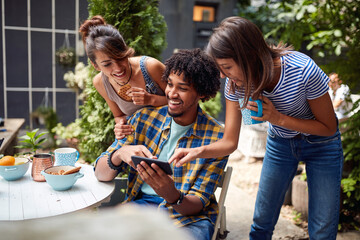 Young man showing funny content of mobile to his friends