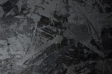 Dark gray concrete or textured putty with stains on the wall, background with copy space