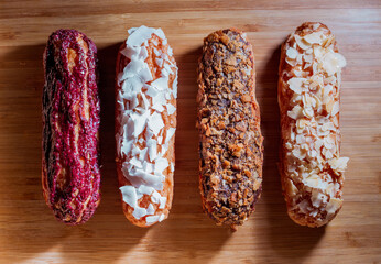 sweet and colorful eclair on wooden background. french eclair. top view