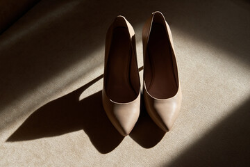 Pastel beige women shoes on beige background, copy space. Trendy fashion feminine background. Beauty blog concept.