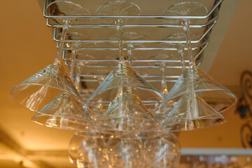 Sparkling wine glasses hanging in bar, copy space