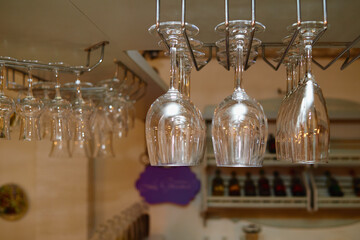 Sparkling wine glasses hanging in bar, copy space