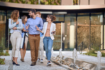 group of colleagues  walking and talking in front of business building