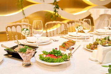 Table setting with blank guest card, plates with napkins and cutlery, copy space. Place setting at wedding reception. Table served for banquet in restaurant