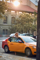 Fototapeta na wymiar Businesswoman getting into yellow taxi