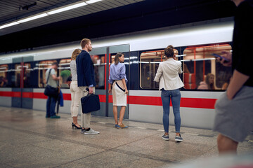 young business people at subway station waiting for a train.