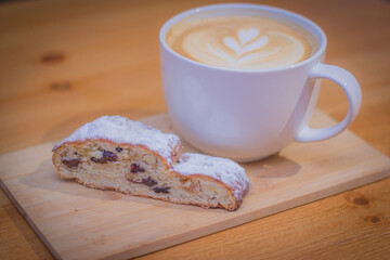 Cappuccino in cup on wood table, with cake