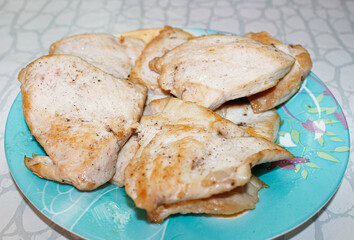 Fried delicious pieces of chicken fillet lie on a plate.